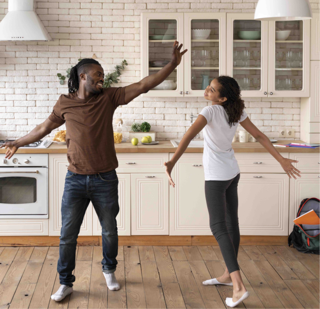 Father And Daughter Having Fun Dancing In The Kitchen